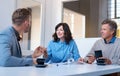 Three smiling work colleagues talking business together in an office Royalty Free Stock Photo