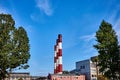 Three smoke pipe made of bricks standing tall with blue sky and trees