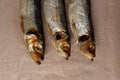 Three smoked sea herring on parchment paper