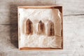 Three smoky natural quartz crystals in a kraft paper box on wooden background. Top view. Copy, empty space for text Royalty Free Stock Photo