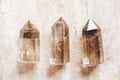 Three smoky natural quartz crystals on wooden background. Top view. Copy, empty space for text