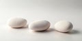 Three smooth white stones arranged in a row on a light background. Generative AI Royalty Free Stock Photo