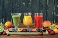 Three smoothies from different fruits and berries such as kiwi, orange, peach, apricot, cherry, strawberry, raspberry Royalty Free Stock Photo
