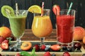 Three smoothies from different fruits and berries such as kiwi, orange, peach, apricot, cherry, strawberry, raspberry Royalty Free Stock Photo