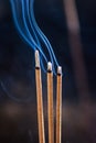 Three smouldering incense sticks with smoke