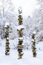 Three snow covered stacks of round rocks in a peaceful snowy zen garden