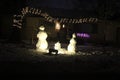 Three Snowmen and Noel Sign at night