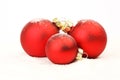 Three snowy red christmas matt balls standing on snow on white background