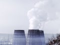 Three soaring evaporators of CHP against the blue sky. White cloud of industrial smoke or couple rises into a clean sky