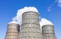 Three soaring evaporators of the thermal power plant against the background of the blue sky.