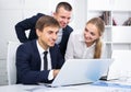 Three sociable coworkers different sexes working in company office Royalty Free Stock Photo