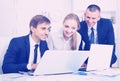 Three sociable coworkers working in company office Royalty Free Stock Photo