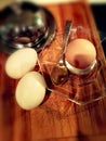 Three soft-boiled eggs for breakfast. One in a glass stand.