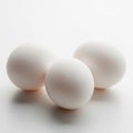 Three soft white textured spheres sit on a smooth surface with subtle lighting effects Royalty Free Stock Photo