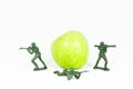 Three Soldier toy protect green apple Royalty Free Stock Photo
