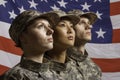 Three soldiers posed in front of American flag, horizontal