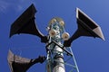 Three speakers hoisted into a light tower