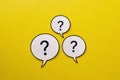 Three speech bubbles with question marks a bright yellow background