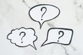 Three speech bubbles with question marks
