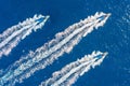 Three speed boats launch at high speed floats in the ocean, aerial top view Royalty Free Stock Photo