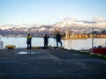 Three spinners in the port area against the backdrop of the mountains. Fishermen in Batumi. Lure fishing. Silhouettes of fishermen