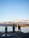 Three spinners in the port area against the backdrop of the mountains. Fishermen in Batumi. Lure fishing. Spinning Royalty Free Stock Photo