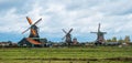 Three spinning Dutch windmills from across farmland in Zaase Schans  Netherlands Royalty Free Stock Photo