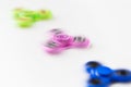 Three spinning fidget spinners on white background Royalty Free Stock Photo