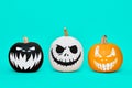 Three Spooky Halloween pumpkins with scary face expressions over pastel blue background. Halloween.