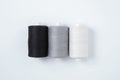 Three spools sewing thread lying in a row. White background Royalty Free Stock Photo