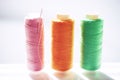 Three spools of thread and a needle on a white bright table, side view Royalty Free Stock Photo