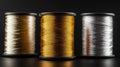 Three spools of thread, one gold, one silver, and one white