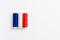 Three spools of thread for sewing are stacked in the form of the flag of France on a white background. Royalty Free Stock Photo