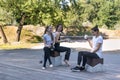 Three sports girls relax in the park with cups of tea. Group of women rest after fitness class
