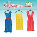 Three spring coctail dresses on a hanger.