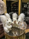 Three squirrels dolls iwith pine cones in hands showcase window of store winter