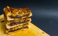 three stack of chocolate filled toasted bread on wooden cutting board with black background Royalty Free Stock Photo