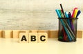 Three stacked wooden cubes with letters ABC on a white desktop on a gray background. Royalty Free Stock Photo