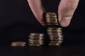 three stacks of coins hand raised piece of coins on black leather