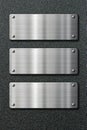 Three stainless steel metal plates on black