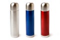 Three stainless steel thermoses red, blue and metal isolated on white background.