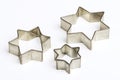 Three star shaped Christmas cookie cutters over white Royalty Free Stock Photo