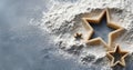 Star-shaped cookie cutters placed on a pile of flour on a gray surface for baking preparation Royalty Free Stock Photo