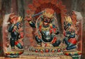 Three statues of black Tibetan deities with gold crowns in a monastery