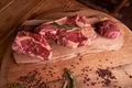 Three steaks of rib eye on a wooden cutting board with a sprig of rosemary, colored peppercorns, dried pickles Royalty Free Stock Photo