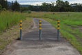 Three steels posts blocking a single lane road