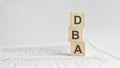 three stone cubes on the background of white financial statements, tables with the word DBA. Strong business concept Royalty Free Stock Photo