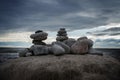 Three stone`s pyramids on the ocean cost with dark cloudy sky background