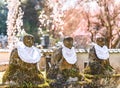 Stone statues of Jizo Bodhisattva wearing a baby bib in front of cherry blossoms. Royalty Free Stock Photo