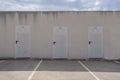 Three storage room doors against a blue sky. Simmetry in a minimalist background. Epmty copy space
